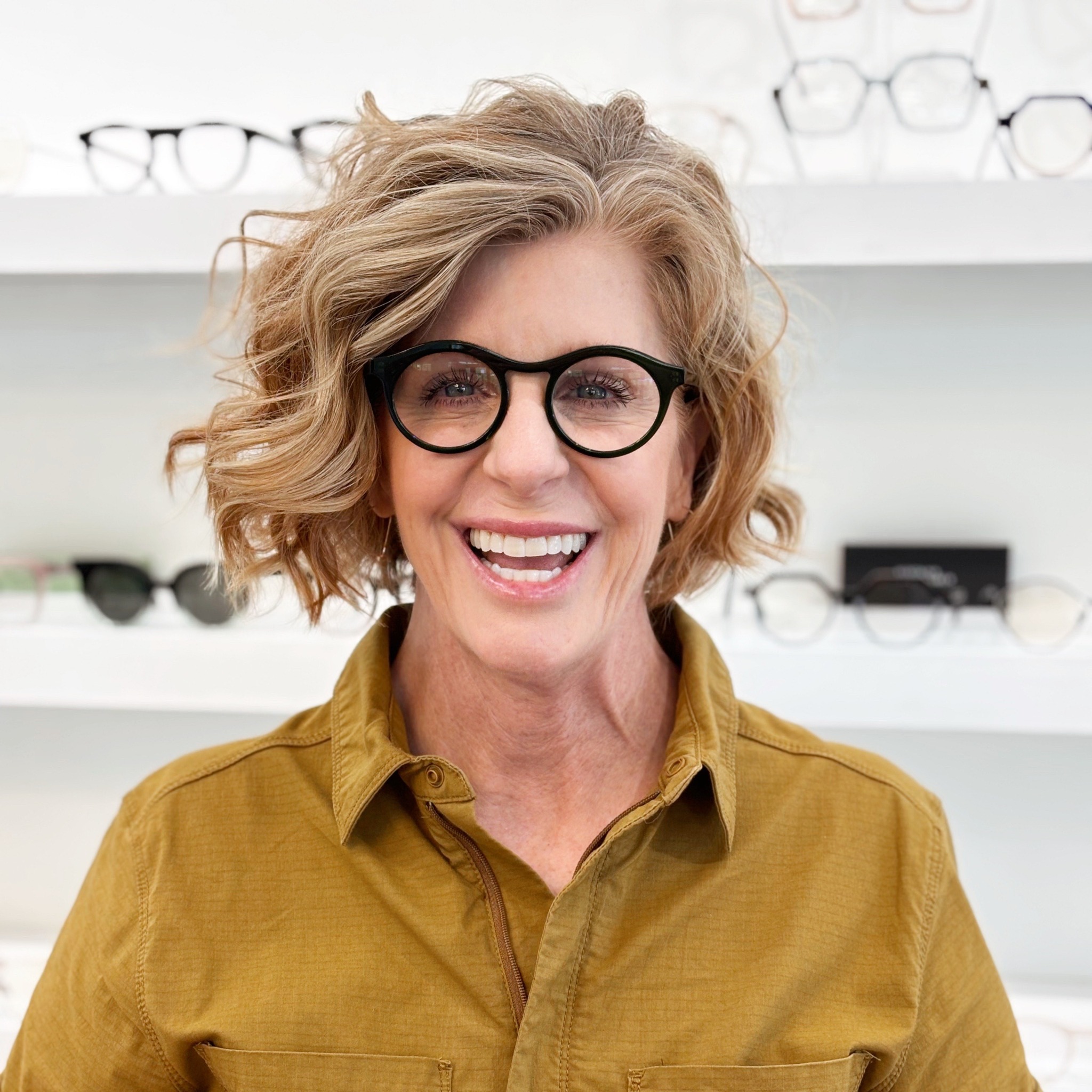 Smiling Bright Side Optical client wearing round green glasses